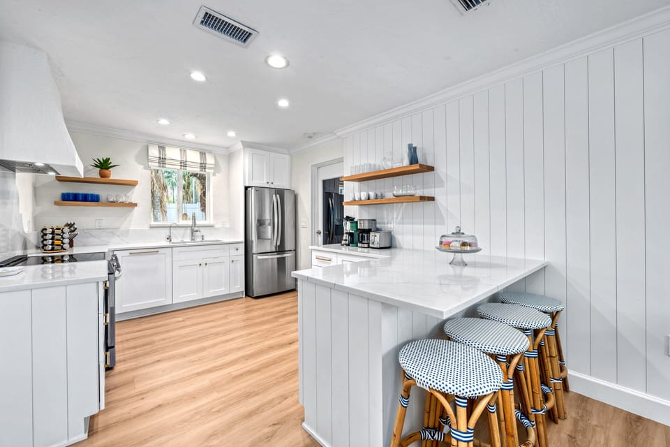 Bright mornings begin here—with smoothies, scrambled eggs, and sunlight pouring in over this sleek, modern island.
