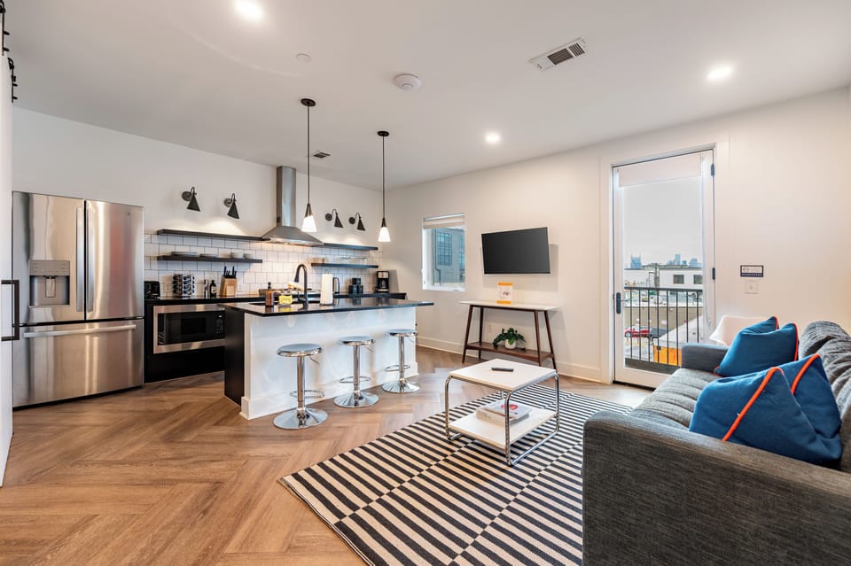 Sleek open-concept living with a modern kitchen and city views.