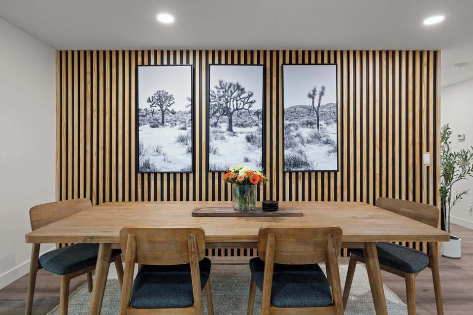 Dine at this modern setting, featuring a striking wood-paneled wall and tasteful artwork.