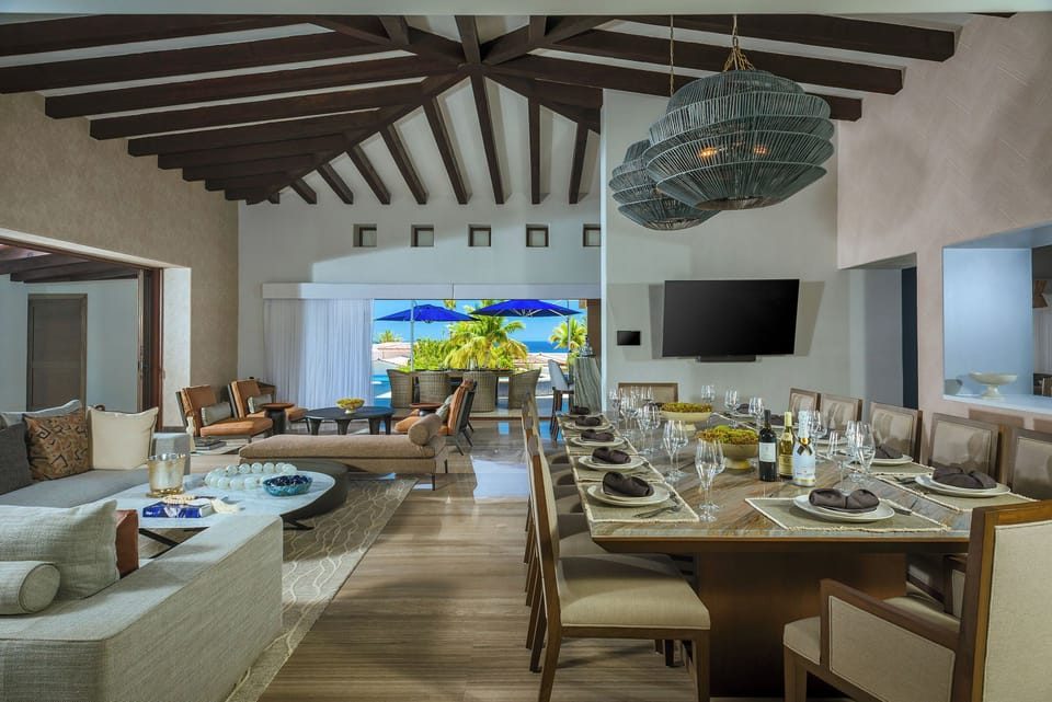Open-plan great room with dining and living areas opening to the pool and ocean at Villa Esperanza in Palmilla Caleta.