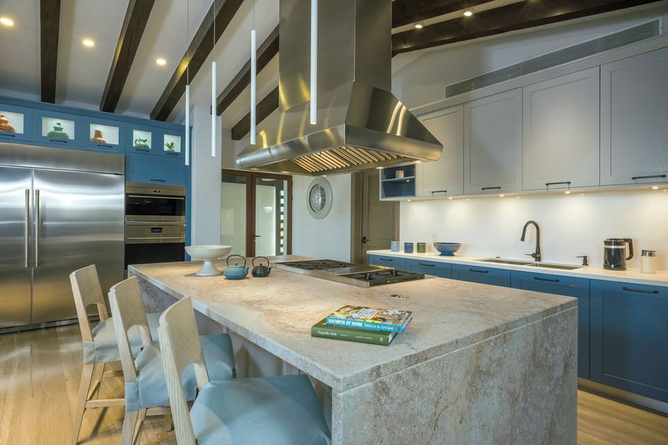 Gourmet kitchen with a stone island and blue cabinetry at Villa Esperanza in Palmilla Caleta, Los Cabos.