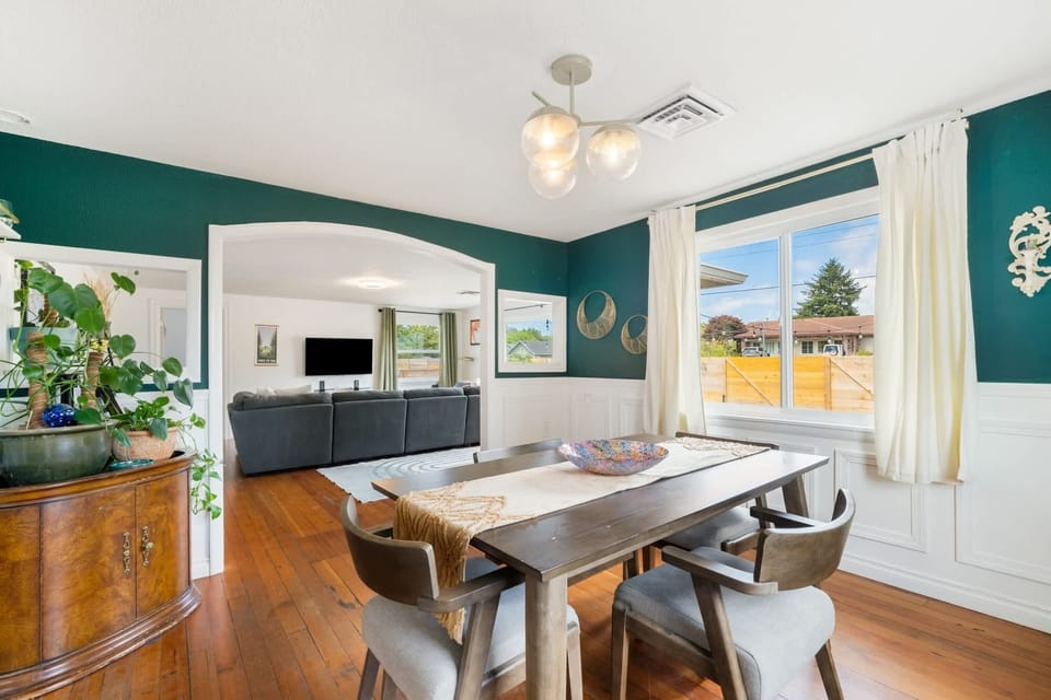 Our bohemian dining space seamlessly connects to the bright, light-filled living room. This open layout keeps everyone together, whether you are eating at the table or lounging on the sofa.