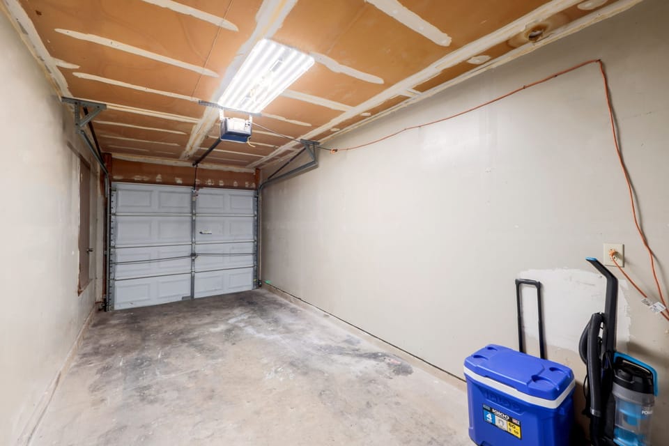 Clean and functional garage space with ample room for parking or storage, featuring bright lighting for convenience.