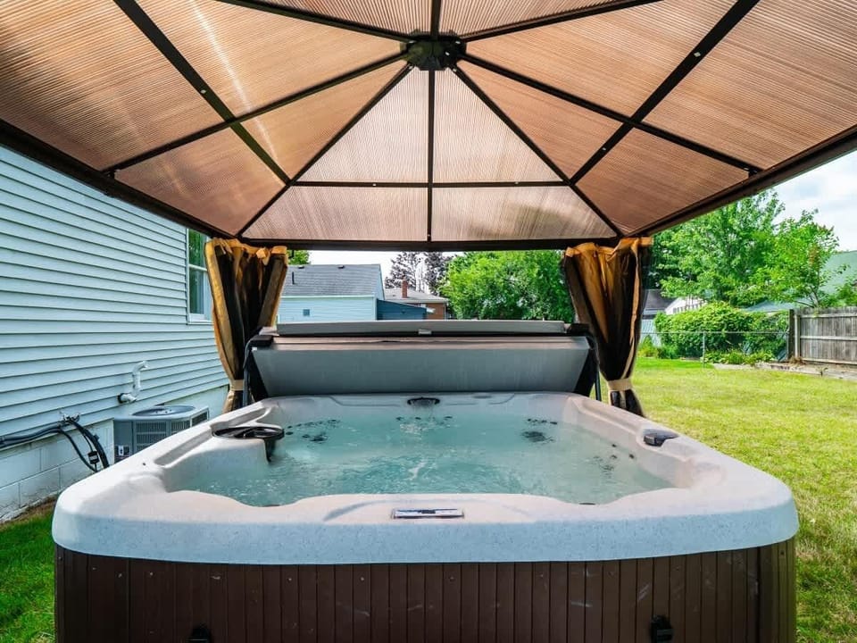 Relax in the bubbling hot tub beneath a shaded gazebo for a soothing outdoor soak