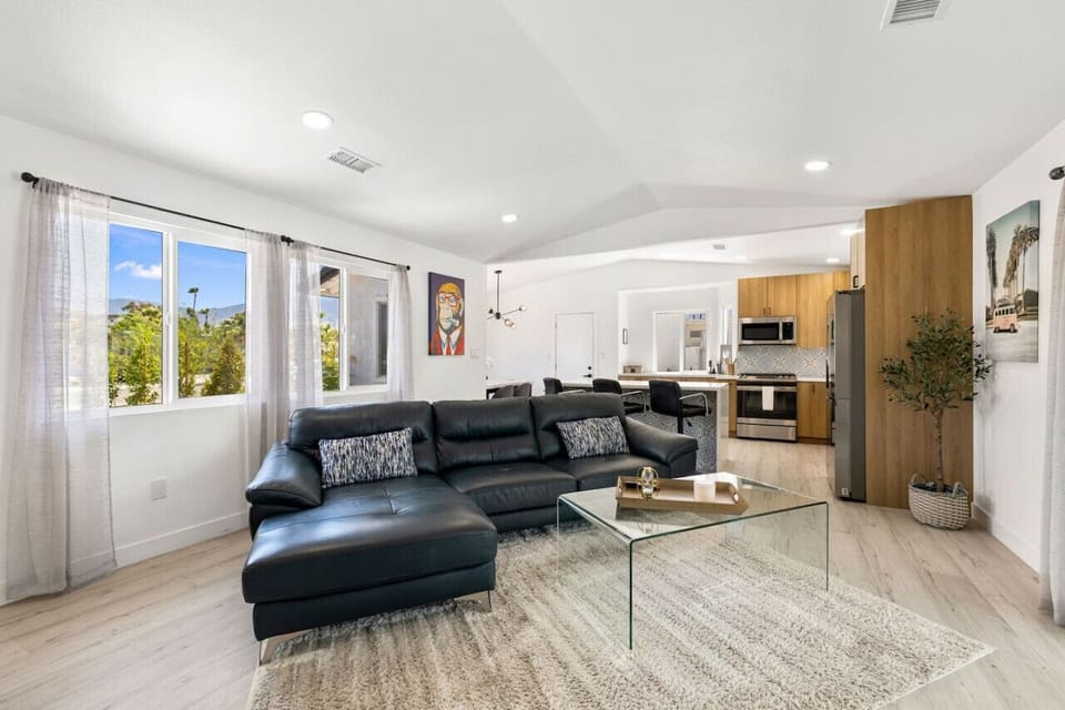 Bright open living space w/ comfy seating flowing into the kitchen, ideal for gathering after a day outside.