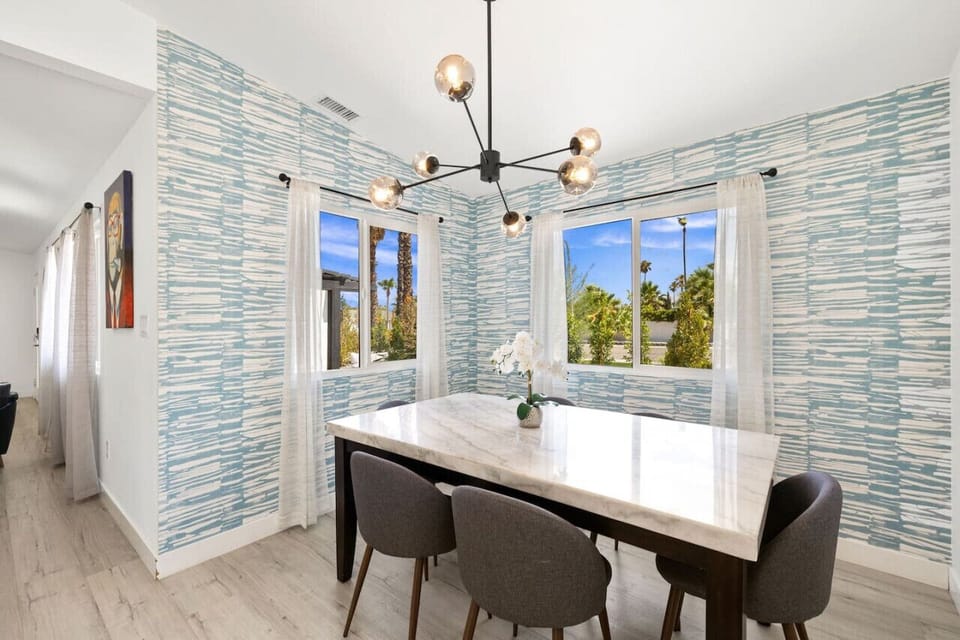 Stylish dining space w/ statement lighting and bold wallpaper that makes every meal feel special.