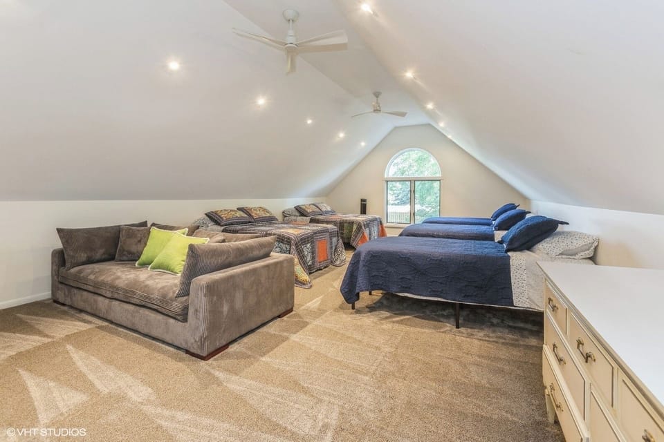 Bunk room with 3 single and 2 full beds, plus a couch and smart tv.