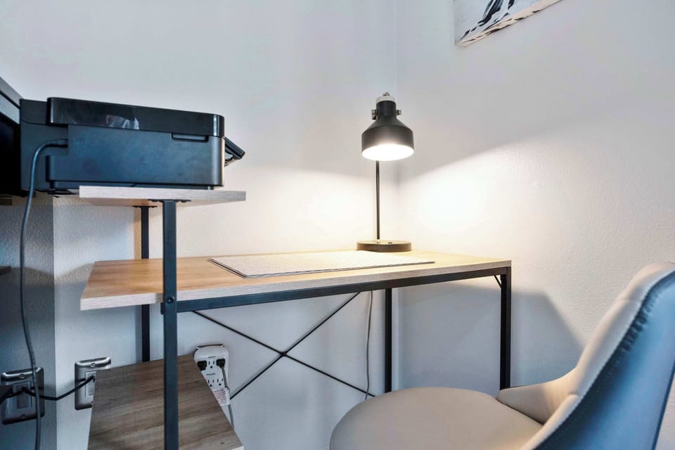 Compact workspace with a desk lamp and printer for productivity.