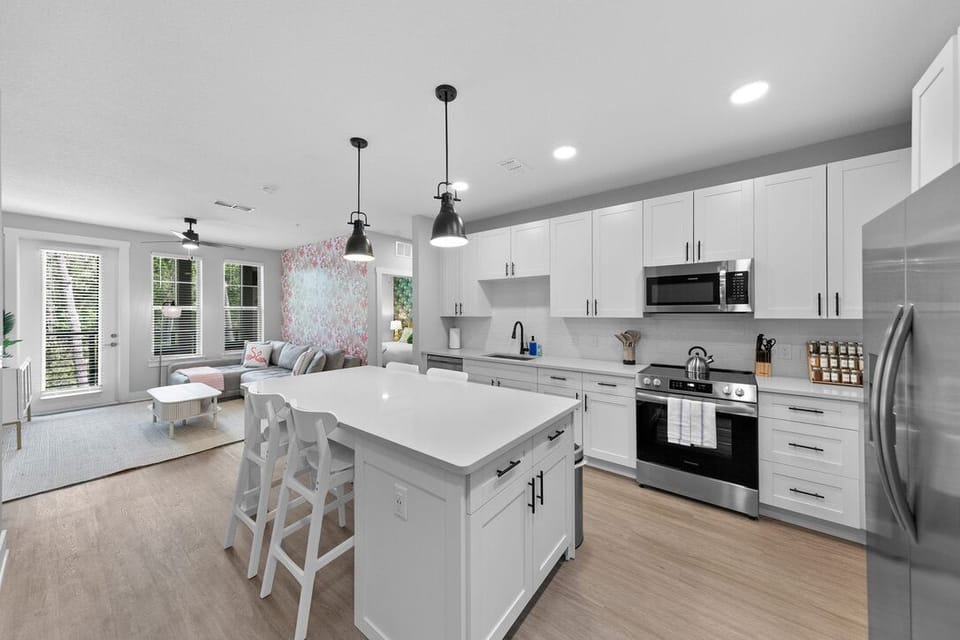 A spacious and modern, bright kitchen that opens into the living and dining areas