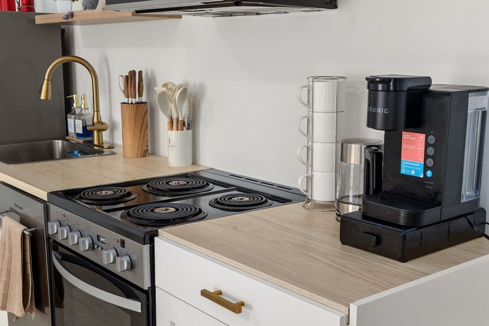 Bright modern kitchenette with coffee station and full stove setup