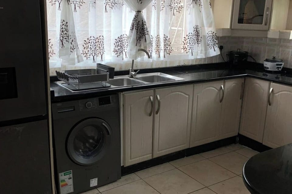 Kitchen with fridge, washing machine, island, gas and electric stove. Great natural light