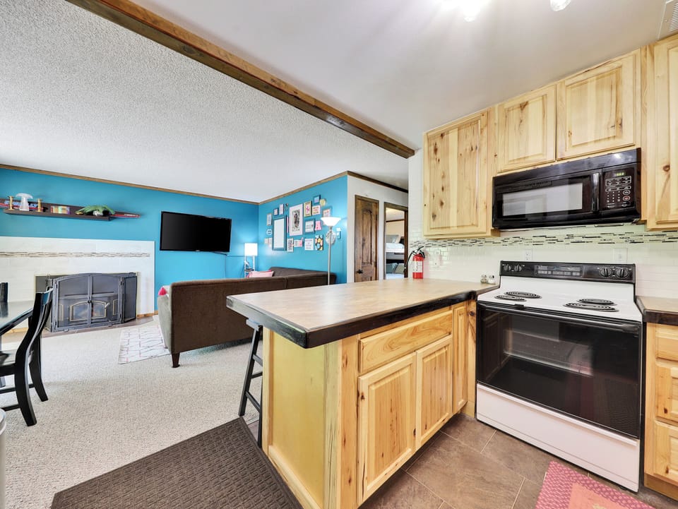 View of Kitchen with Counter Seating for 4, Electric Oven/Stove, & Microwave with Ample Counter Space