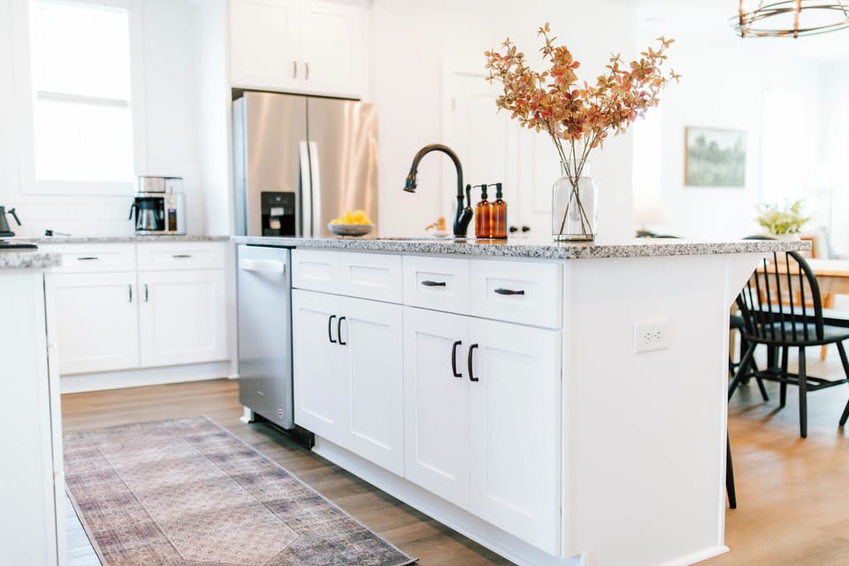The kitchen features a modern island with a built-in sink, perfect for meal prep or casual dining. This stylish centerpiece adds both function and charm to the open, contemporary space.