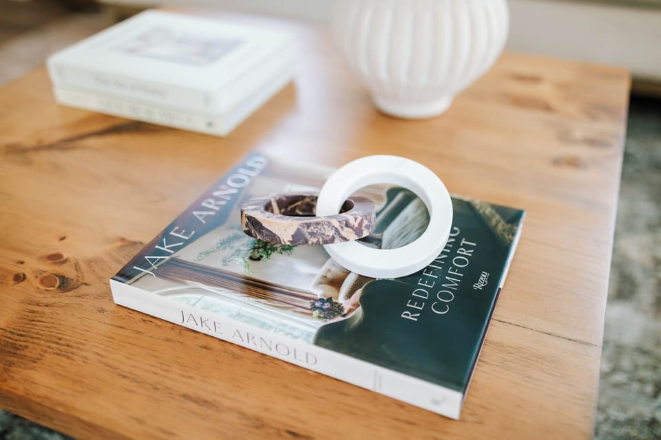 The coffee table books on the coffee table are arranged neatly, showcasing their elegant covers and adding a stylish touch to the living space. These curated selections invite guests to relax and enjoy a read.