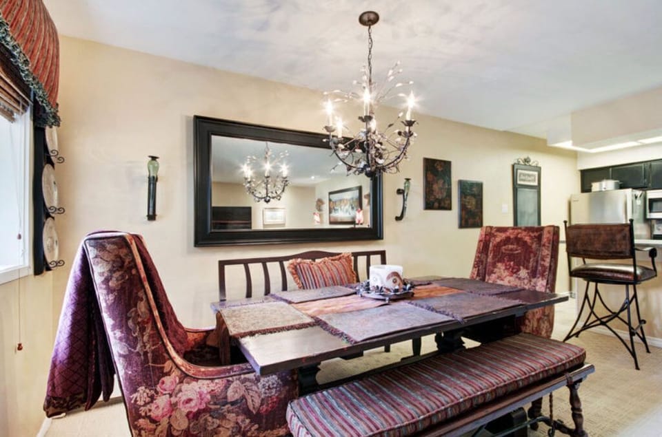 Dine in style in the elegant dining area, featuring a chic chandelier, a large dining table with comfortable seating for six, and easy access to the kitchen for convenient meal preparation.