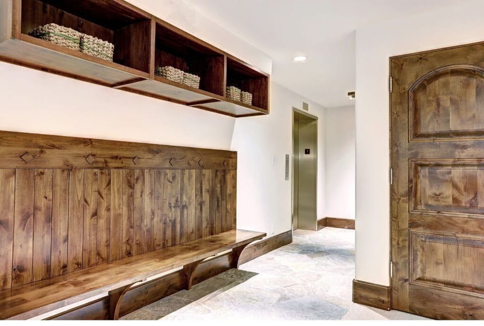 Keep your outdoor gear organized in the functional mudroom, featuring wooden benches, ample storage, and easy access to the rest of the home.
