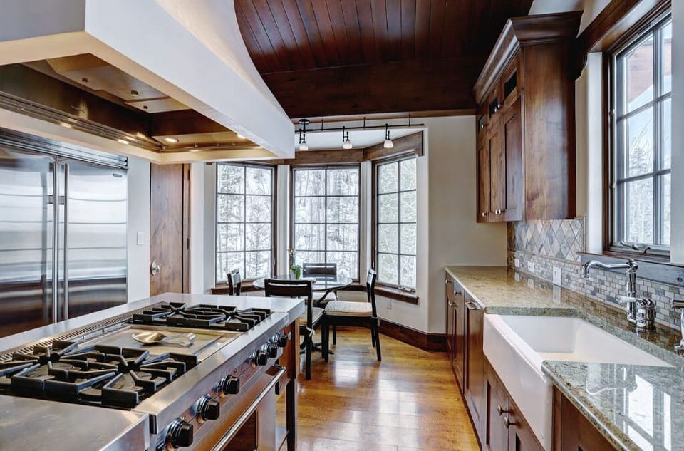 Cook in style in the modern kitchen, featuring stainless steel appliances, a spacious island with a gas cooktop, and plenty of natural light from large windows.