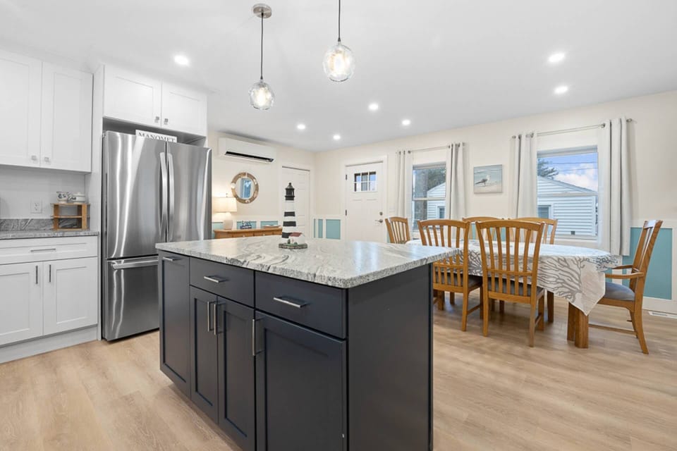 View of the kitchen with large island, fridge with water dispenser, and dining room table