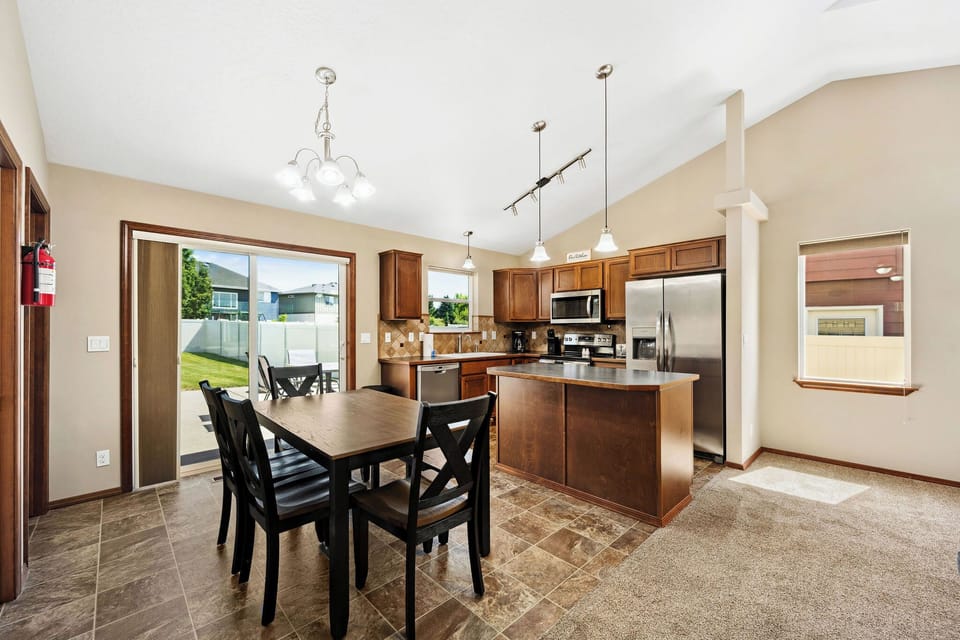 Your spacious kitchen and dining area features warm wood cabinetry, stainless steel appliances, and opens to a sunny patio through sliding doors.