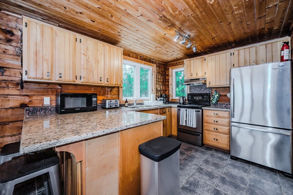 Cook up a feast in this fully-equipped kitchen with gleaming granite countertops, sleek stainless steel appliances, and rustic wooden cabinets, making meal prep a joy.
