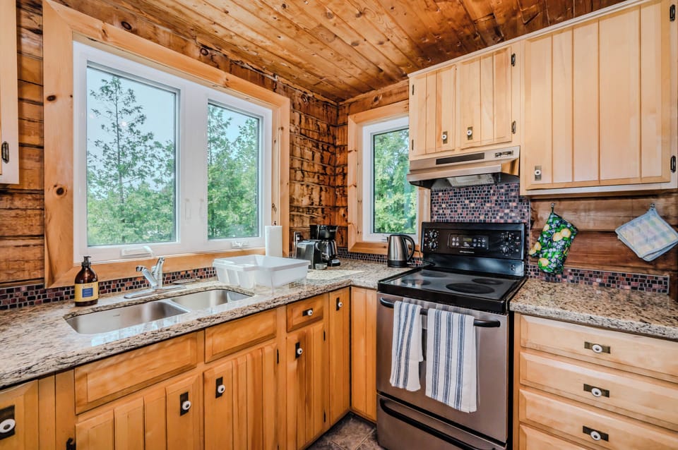 Prepare your meals with a view in this well-appointed kitchen, boasting contemporary appliances and picturesque window views of the surrounding nature.