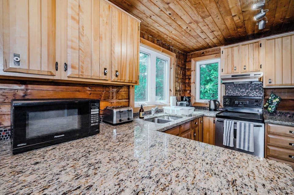This kitchen is a cook's paradise with its modern amenities, spacious granite countertops, and plenty of natural light pouring in from the windows.