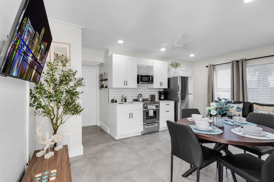 The full kitchen includes a coffee maker, kettle, microwave, fridge with freezer, and a 4-burner stove with oven, plus all essentials for cooking.