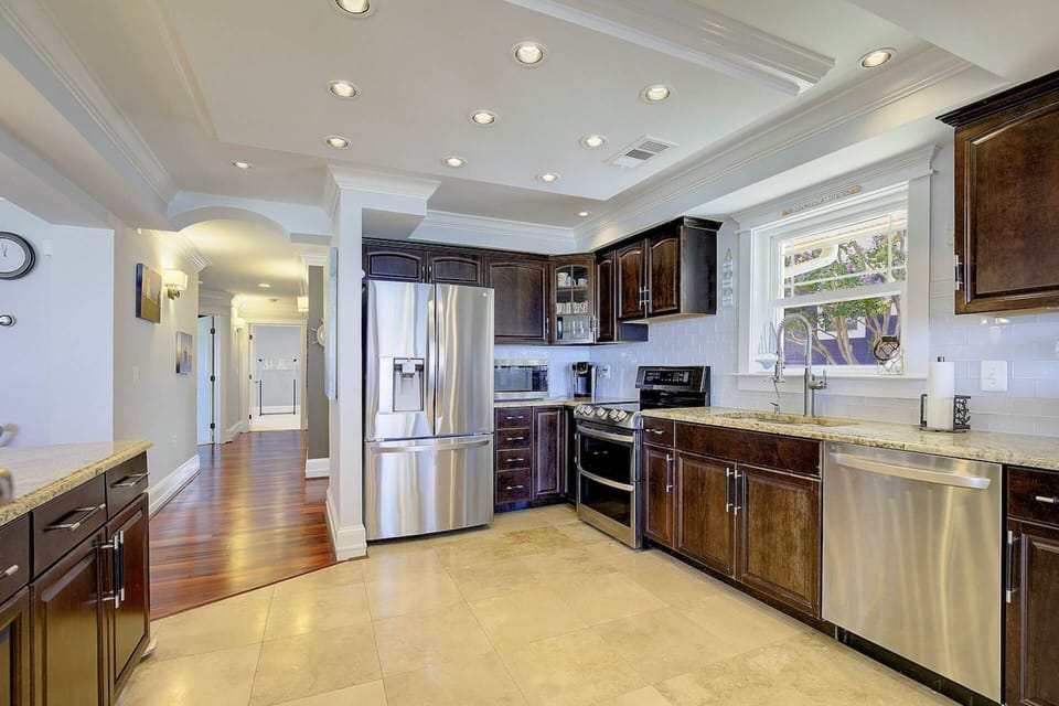 The stainless steel appliances include the large refrigerator with built-in ice maker and water dispenser.