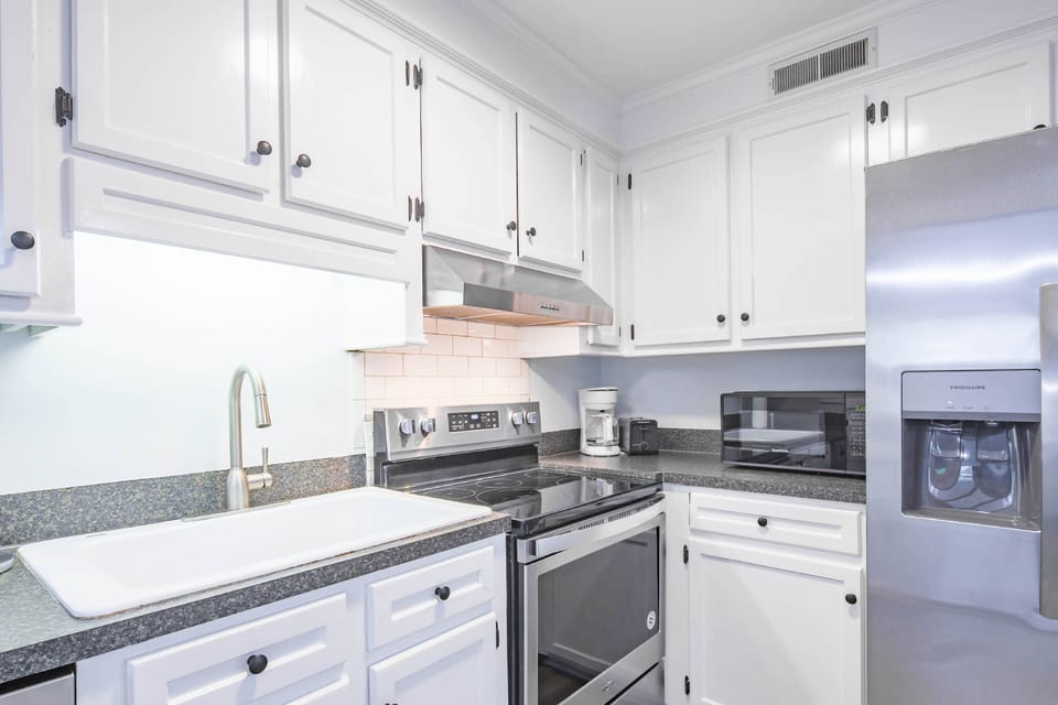 The Blue Oyster features a spacious kitchen with white cabinetry and stainless steel appliances.
