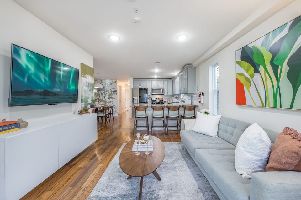 Open-concept living area with stylish sofa, breakfast bar, and modern kitchen amenities.
