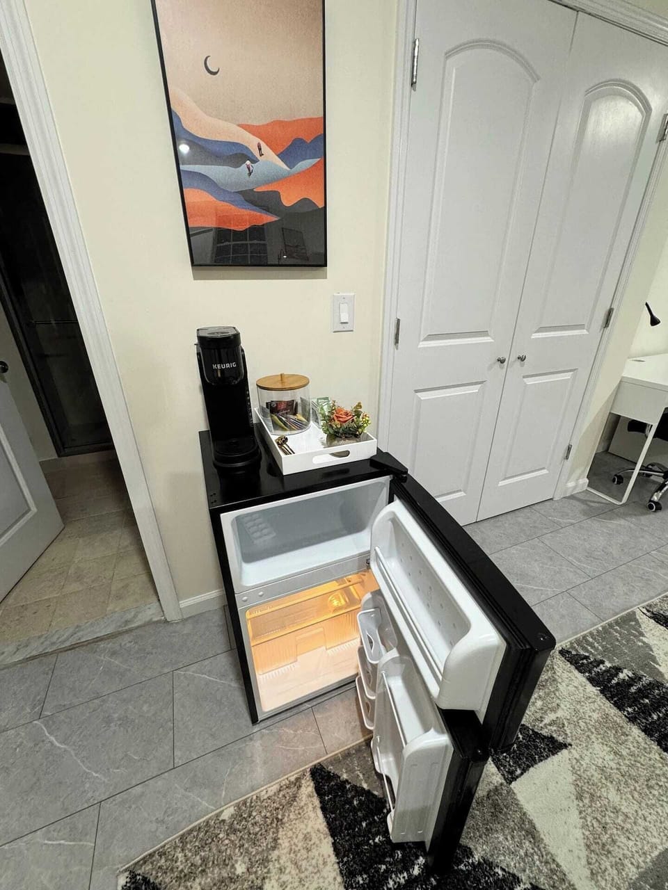 Mini fridge with freezer, Keurig coffee station, and modern decor for easy convenience.
