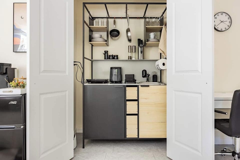 Sleek kitchenette with modern appliances, cookware, and ample storage space.