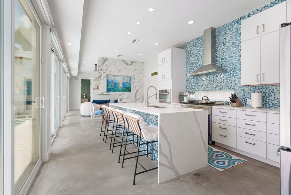 Discover your dream kitchen with a stunning turquoise mosaic backsplash, sleek marble waterfall island, and top-tier stainless appliances—perfect for cooking up memories during your stay.