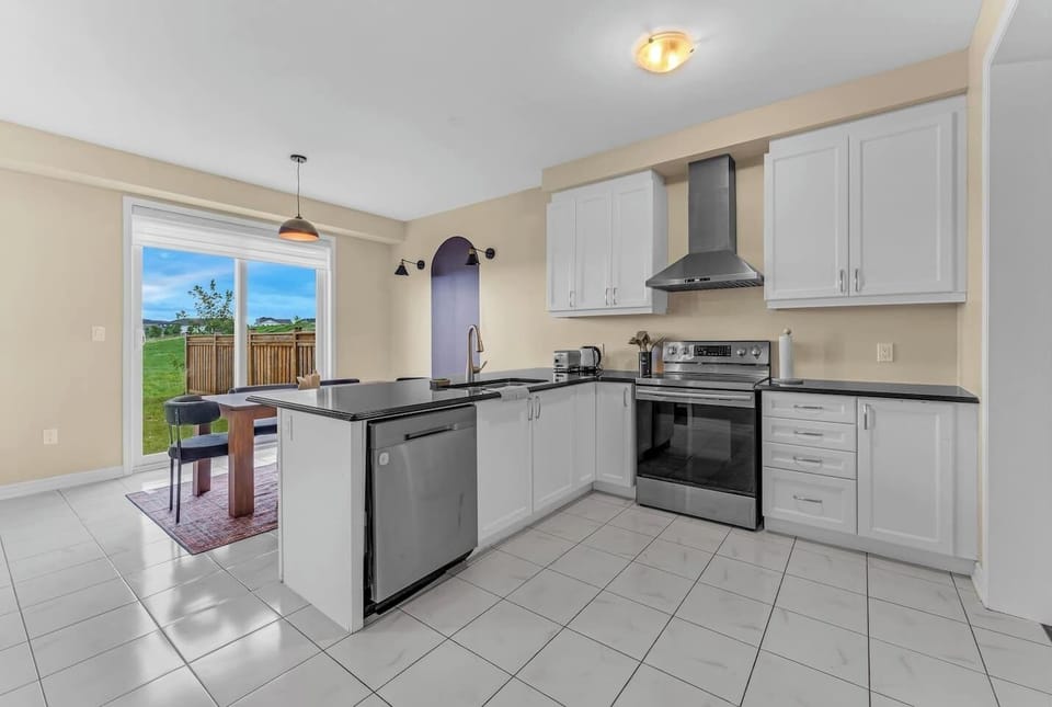 Modern kitchen with sleek appliances, ample space, and a dining area with scenic views!
