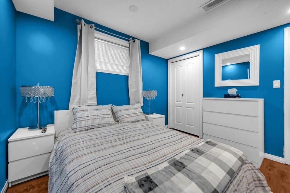Masterbedroom with a large smart TV in room and queen size bed. 