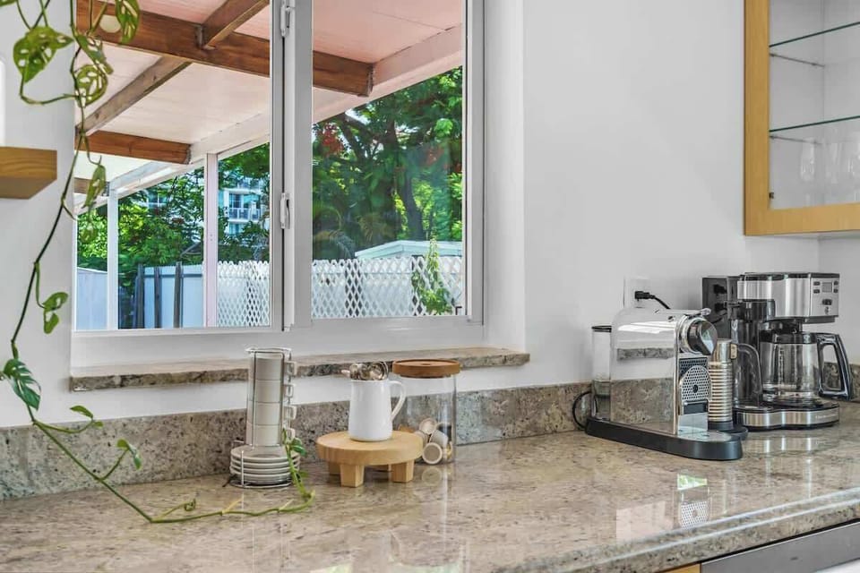 Enjoy this bright, open-concept kitchen with plenty of prep space and garden views. This fully equipped vacation rental makes it easy to whip up local flavors or brew a fresh morning latte ☕.