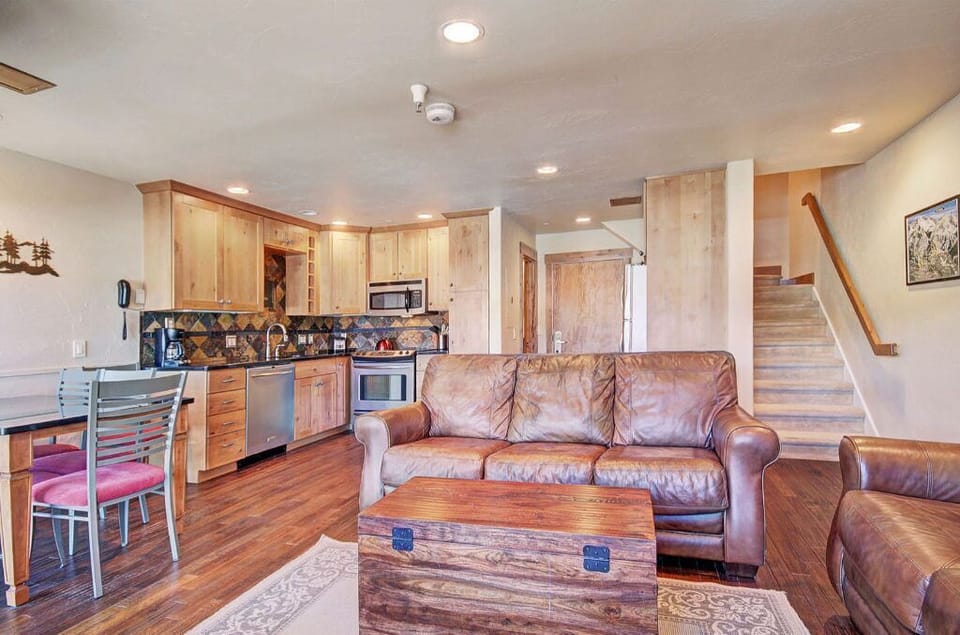 Modern kitchen equipped with stainless steel appliances and a breakfast bar, seamlessly connected to the living area.