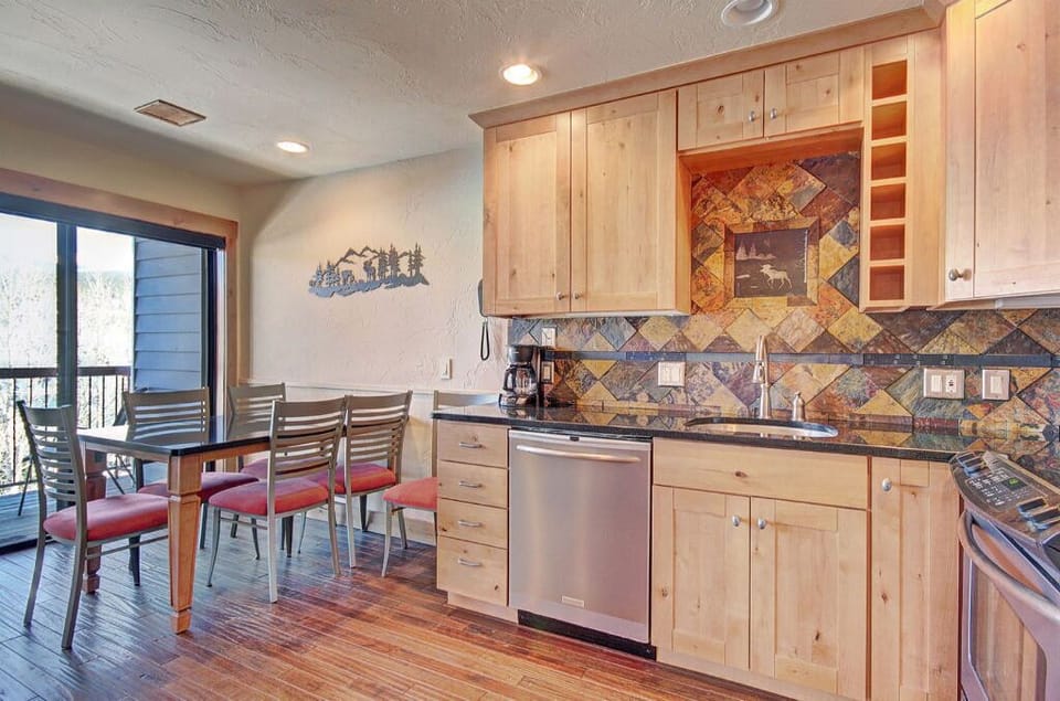 Bright dining area adjacent to the kitchen, featuring a large table and bar seating for family meals.