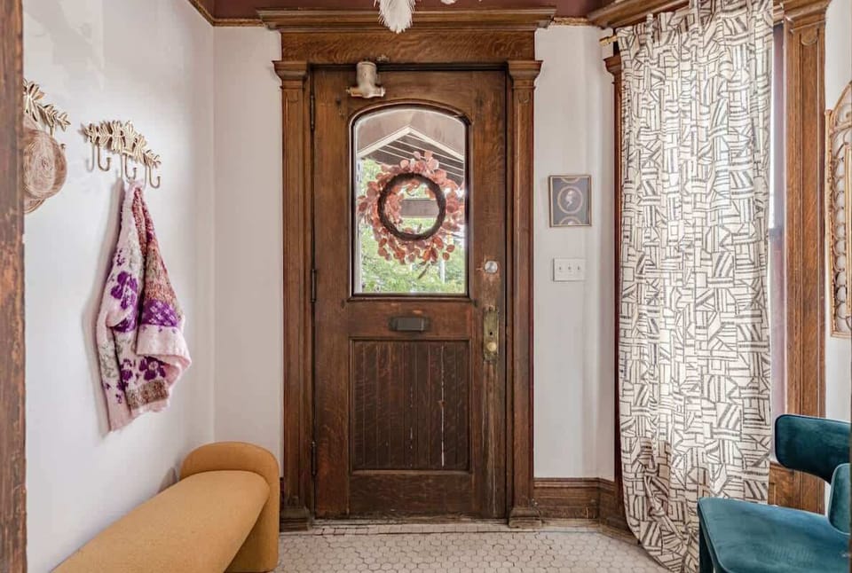 Entryway w/ detailed wood door, vintage charm & inviting natural light