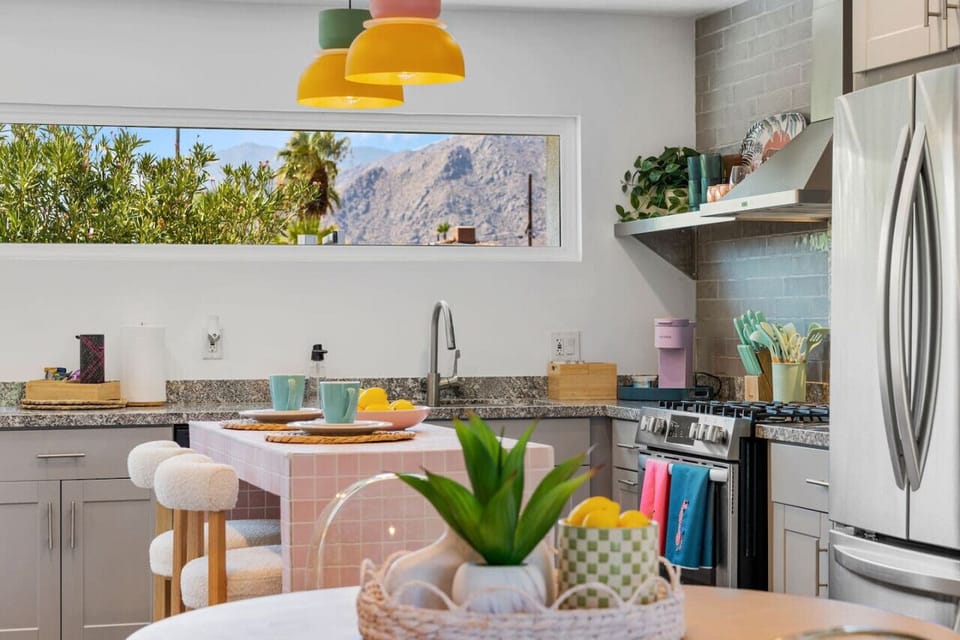 Bright dining nook w/ playful art, modern tableware & a welcoming spot to start the day.