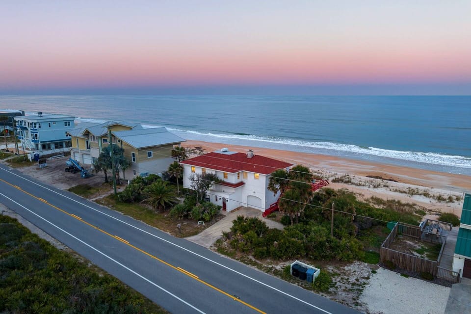 Oceanfront aerial view of The Beach Bum at sunset – direct beach access right behind the house!