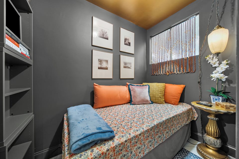 Snug bedroom nook w/ daybed, colorful pillows & framed wall art