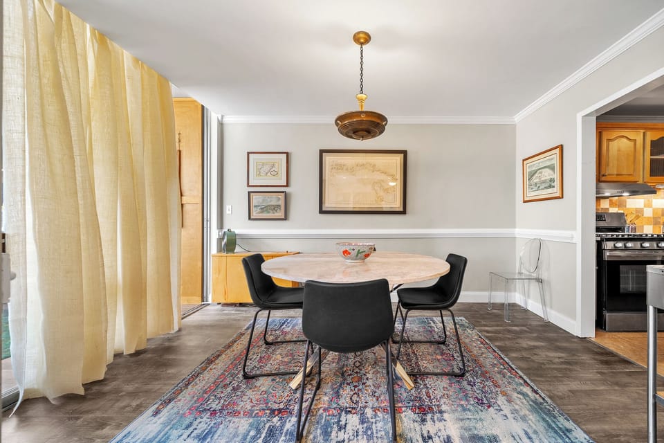 Stylish dining room w/ curated artwork, neutral tones & warm lighting