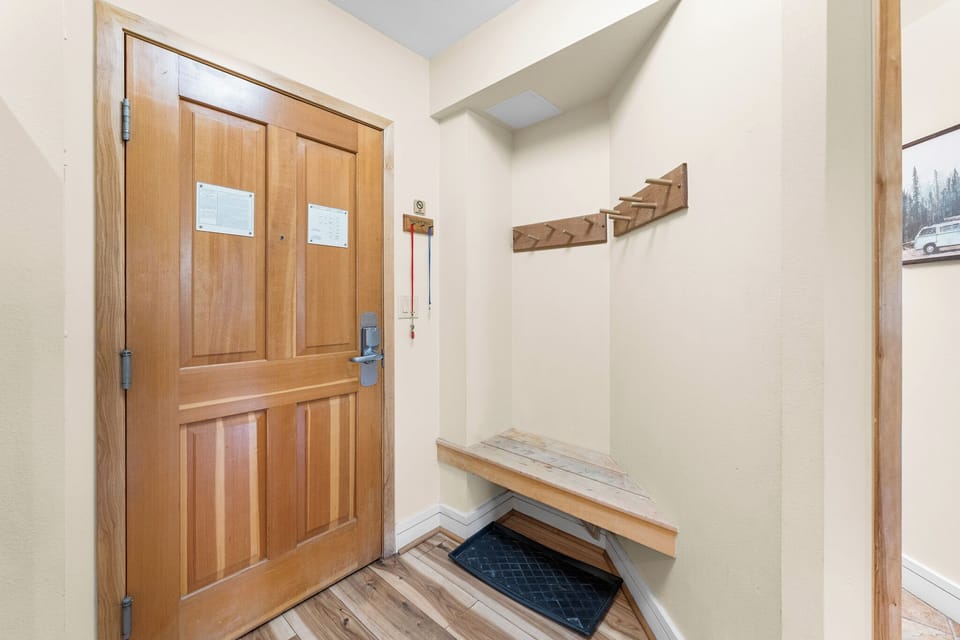 Your welcoming entryway features warm wood tones, a convenient bench for gear, and thoughtful hooks to keep your belongings organized.