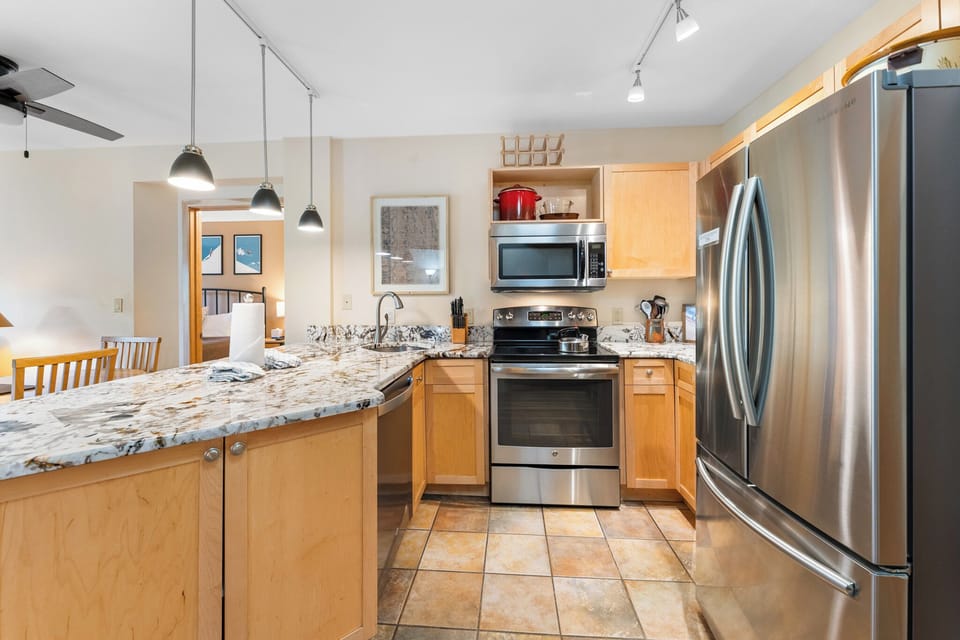 Your fully-equipped kitchen invites culinary adventures with granite countertops, stainless steel appliances, and warm wood cabinets creating the perfect cooking sanctuary.