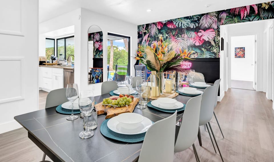 Colorful dining space featuring bold tropical wallpaper and contemporary lighting. Perfect for entertaining and modern living #DiningRoom #TropicalTheme #ModernDining #BoldDesign #EntertainmentSpace #TropicalLiving #ContemporaryStyle #DiningInspo