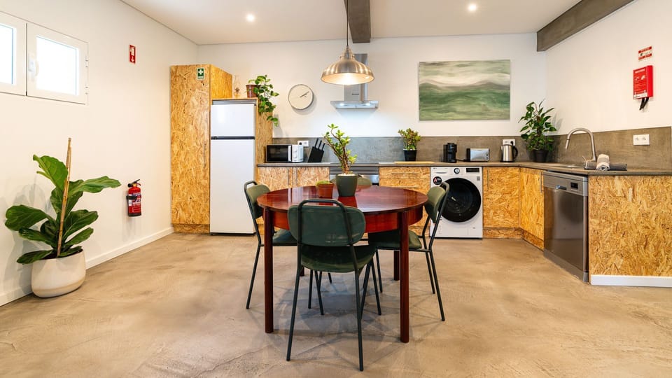 Modern kitchen  with an industrial pendant lights. Adjacent dining area features a rustic wood table #modern #industrialdecor