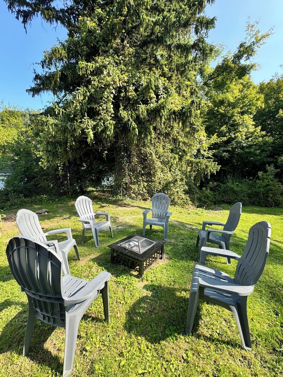 Backyard with firepit, seating and charcoal grill. 