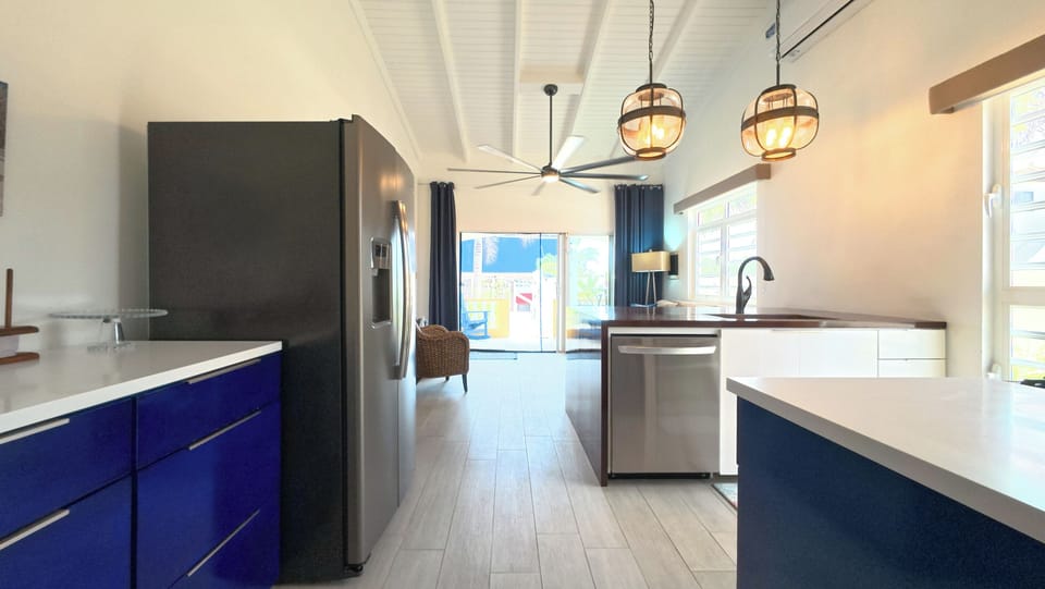 The kitchen is airy and bright, featuring stylish navy and white cabinets that add a fresh coastal feel - creating a cheerful space that is as functional as it is inviting.