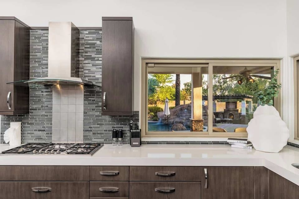 Your modern kitchen opens to a resort-style pool and outdoor lounge, making meal prep feel like a vacation in itself.